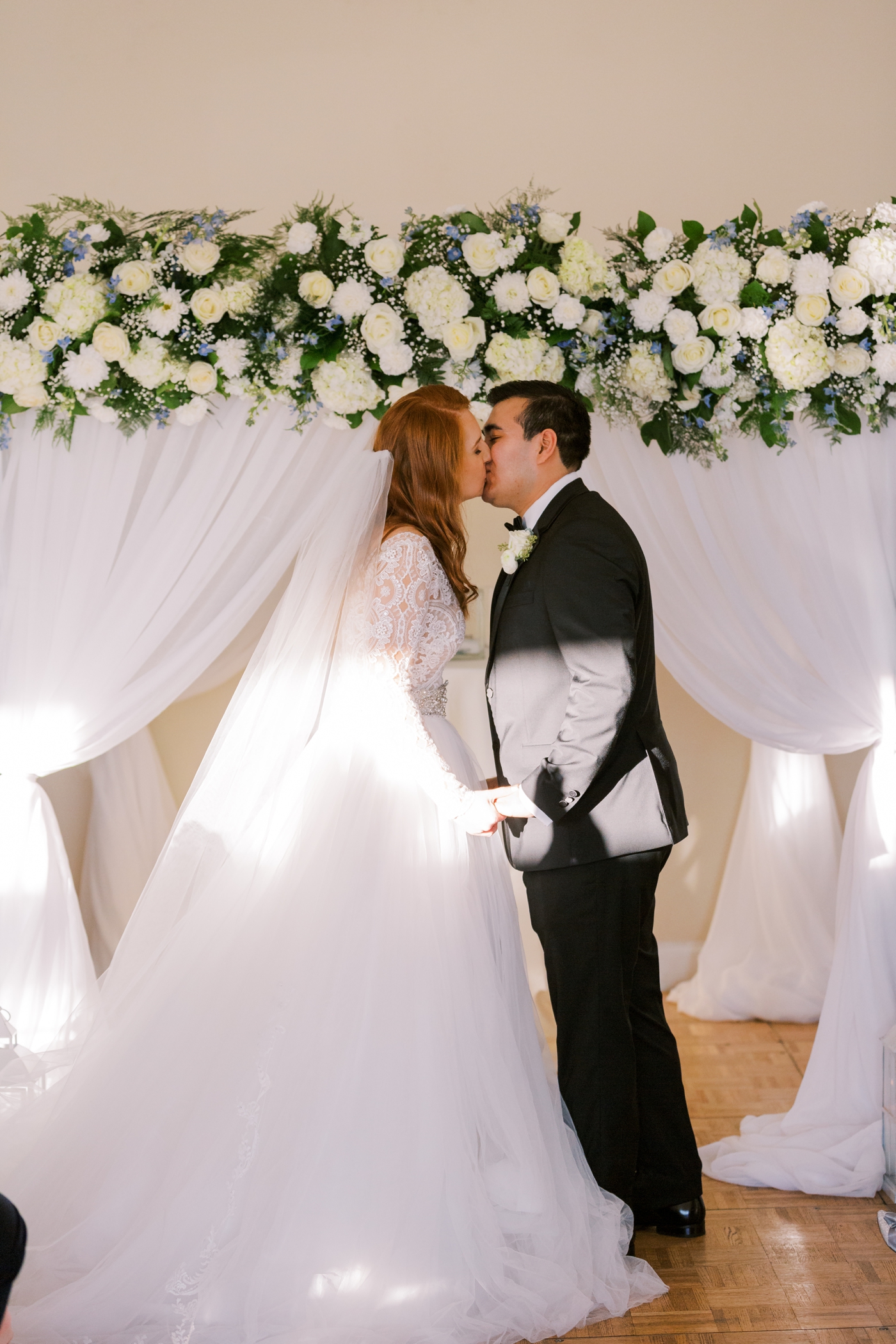 First kiss at indoor wedding ceremony